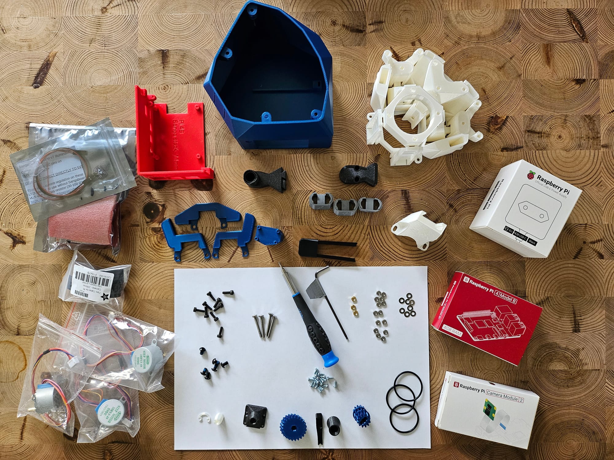 Imaage of scattered materials, 3D printed parts, and screws for the workshop.